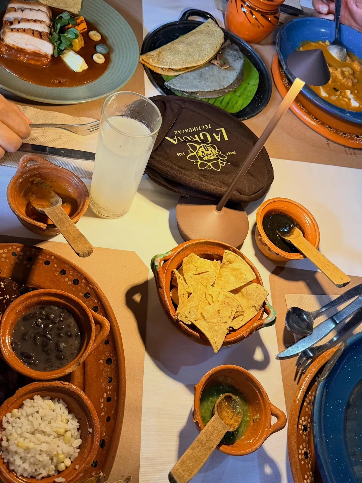 Mesa de desayuno en La Gruta Teotihuacán con quesadillas de tortilla azul, frijoles negros, arroz, totopos y salsas servidas en cazuelitas de barro